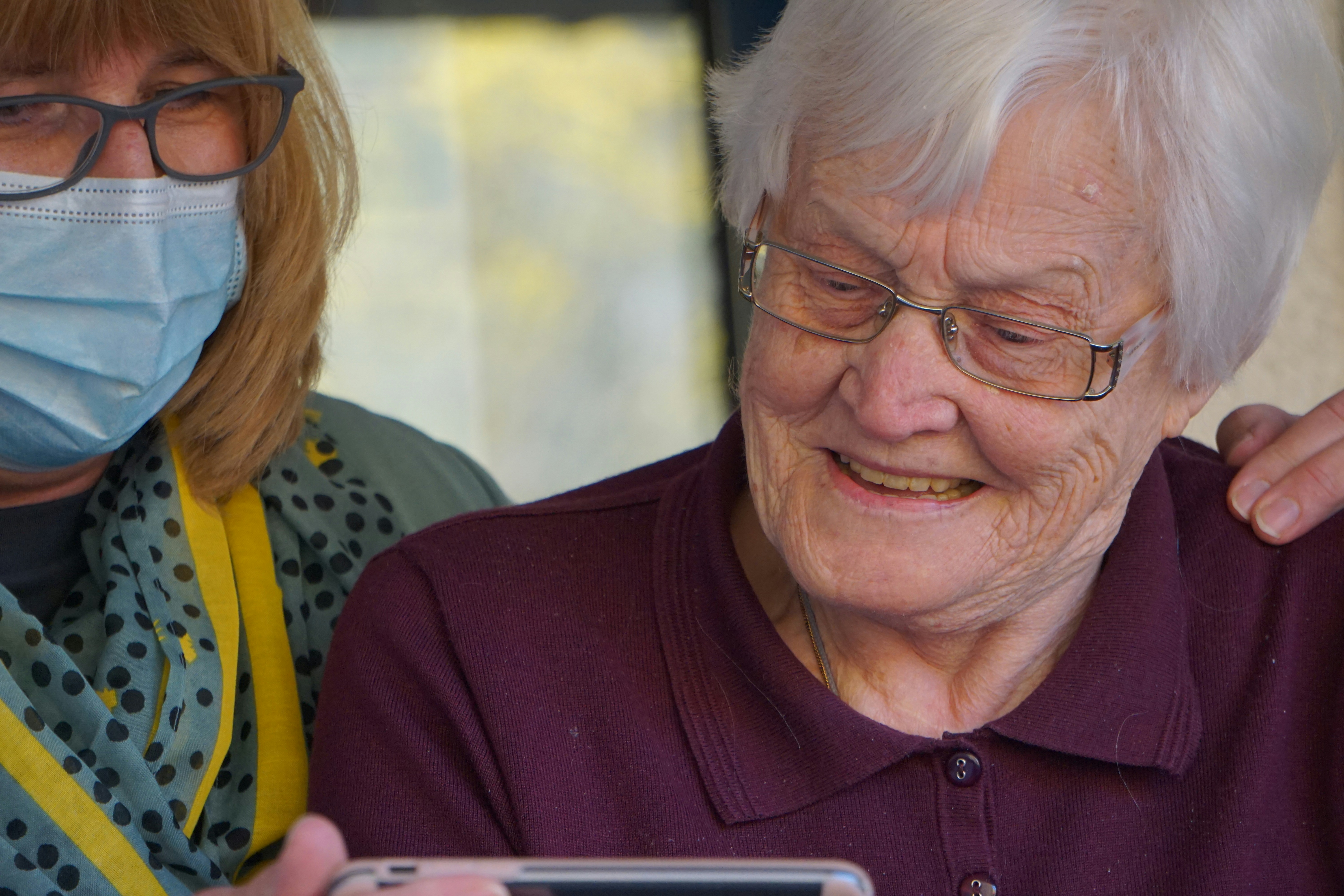 Care worker using a tablet with an older resident